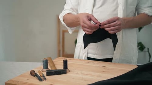 Retro-Lifestyle, Nahaufnahme, Handwerker, der mit Taschen oder Schuhen aus Naturleder arbeitet, kleine Unternehmen