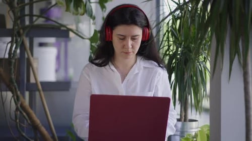 Front View Confident Caucasian Freelancer Listening to Music in Headphones Messaging Online on