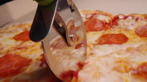 Pizza Cutter Slicing a Fresh Pizza