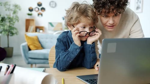 Child and Woman Using Laptop Together at Home
