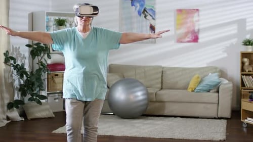 Senior Woman Exercises in Living Room With VR Headset