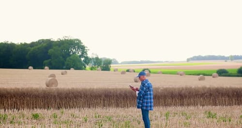 Farmer Using Digital Tablet While Examining Field