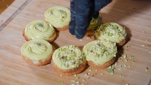 Small Pieces of Pistachio are Placed on Pastries with Custard