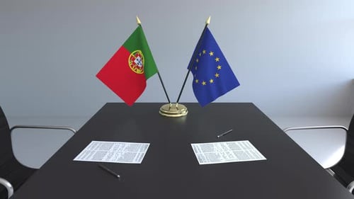 Portugal and EU Flags on Conference Table for Diplomatic Meeting