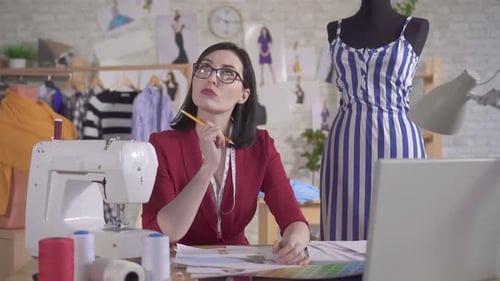 Fashion Designer Working at Table in Studio