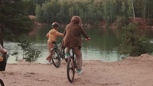 Family With Bicycles In Park With Pond