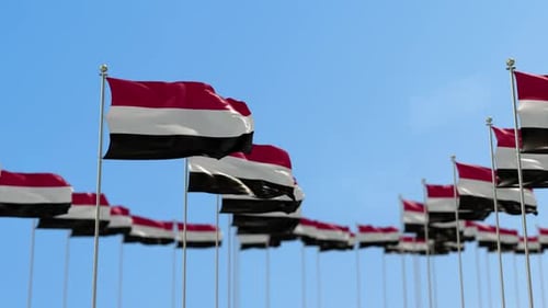 Multiple Waving Yemen Flags on Clear Blue Sky Background