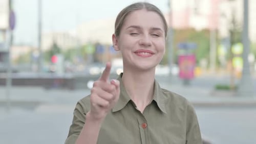Young Adult Woman Points and Smiles