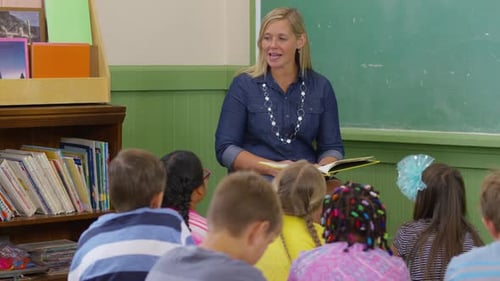Teacher reads book to kids in school classroom
