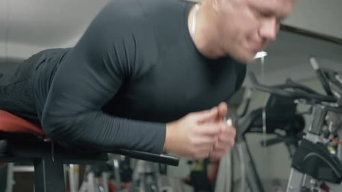 Fisiculturista treina músculos lombares em uma academia