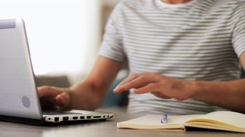 Man with Notebook and Laptop at Home Office