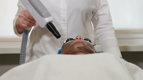 Woman Receives Laser Facial in Medical Setting