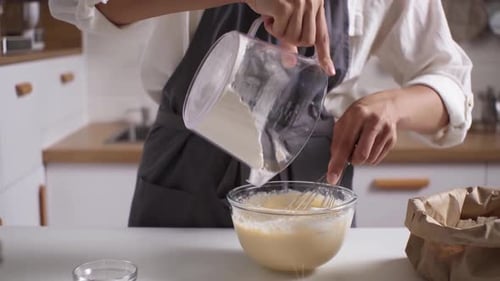Adding Flour to Batter in a Kitchen