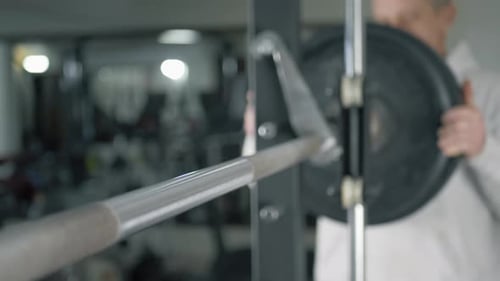 Athlete Bodybuilder Puts Weight on Barbell