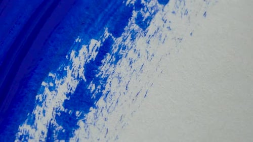 Drawing with a Paintbrush on White Paper with Blue Acrylic Paint Close Up