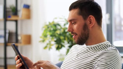 Man Using Tablet at Home in Daytime