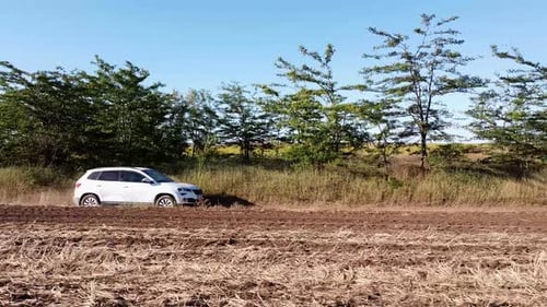 is a Car That Drives at High Speed on a Rural Road in a Field