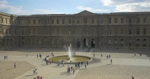 Pessoas andando na praça perto do Louvre em Paris