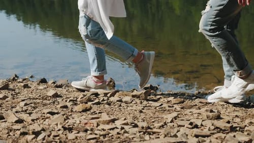 Zwei Wanderer gehen am felsigen Ufer des Sees entlang