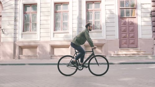 Cyclist Man Riding Fixed Gear Sport Bike in Sunny Day on a City