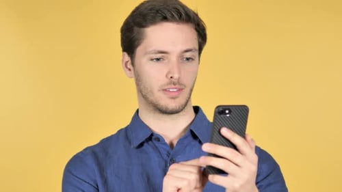 Man Smiling and Using Smartphone Device