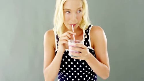 Woman Sips a Drink With a Straw