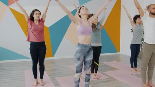 Women and Man in Sportswear Doing Yoga Balancing Asanas in Sports Club