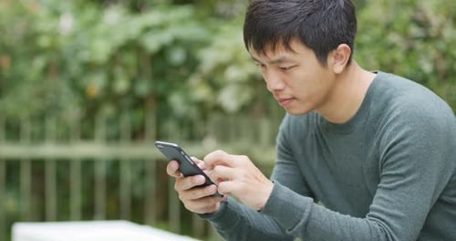 Man Using Mobile Phone in Urban Park Setting