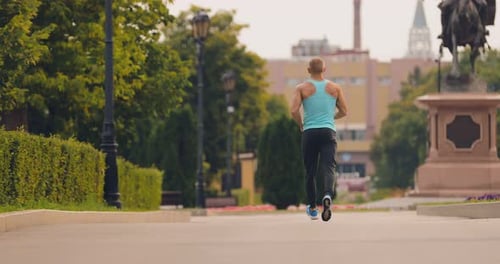Man Running on Sidewalk in Park