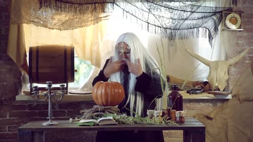 Senior Wizard Casting Spell on Pumpkin Indoors