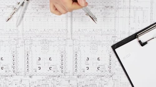 Engineers Are Sitting at the Table Analyzing the Drawing. Close Up
