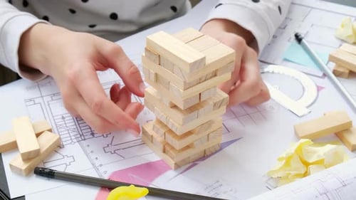 Wooden Game Construction on Desk with Architectural Drawings