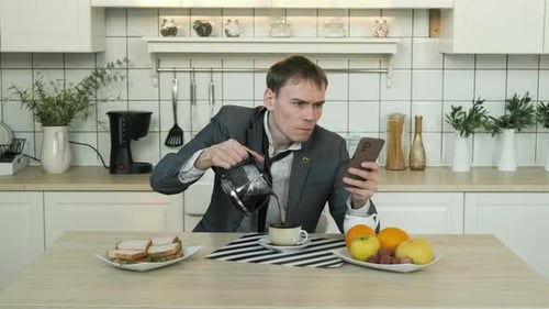 Man Pours Coffee While Looking at Phone
