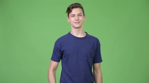 Young Adult Gives Thumbs Up in Front of Green Screen