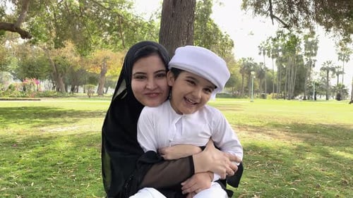 Arabische emiratische Mutter mit arabischem Sohn. Frau in Abaya mit einem Jungen in Kandora. Familie aus dem Nahen Osten