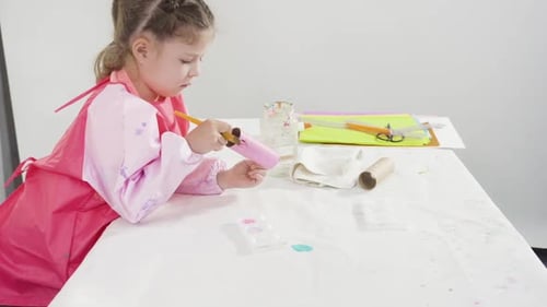 Girl Painting Cardboard Tube Pink in Studio