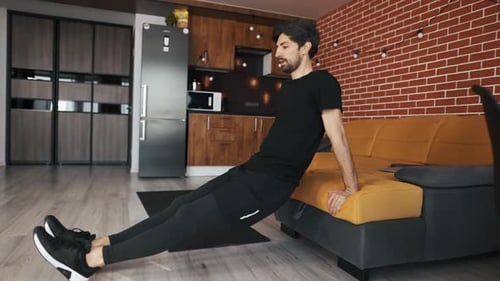Man Doing Tricep Dips At Home on Couch