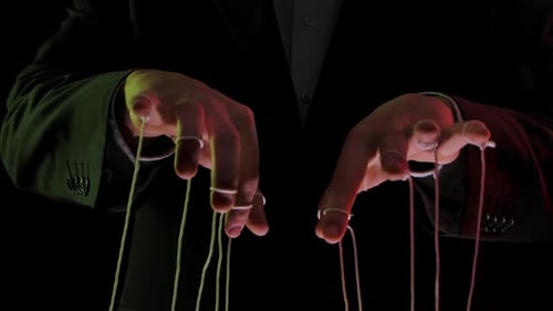 Geschäftsmann Leader in einem Anzug manipuliert die Marionettenschnüre, die an seine Finger gebunden sind