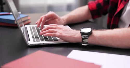 Close Up of Teenage Boy's Hands Typing on Laptop Keyboard