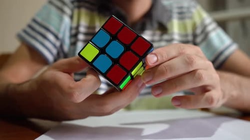 Mãos de homem resolvendo o cubo de Rubik. Jogo de quebra-cabeça. close up