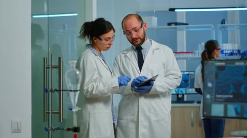 Scientists Collaborate Using Tablet in Bright Laboratory