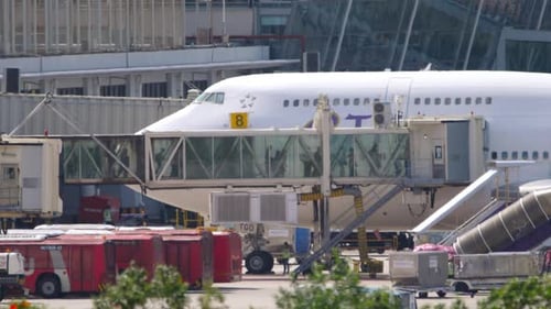 Airplane at Terminal with Passengers Boarding Jet Bridge