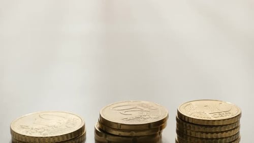 Stacks of Shiny Euro Coins on White Surface