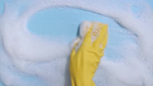 Hand in Yellow Glove Cleaning with Sponge