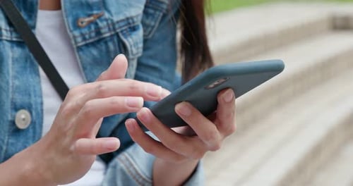 Adult Hands Using a Cell Phone Outdoors
