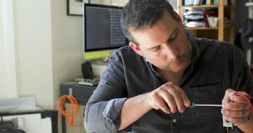 Man Working on Electronic Device at Home