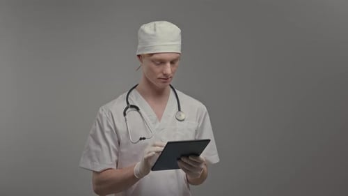 Medical Professional Using Tablet in Hospital Setting