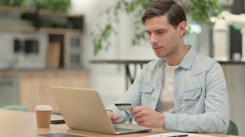 Erfolgreiche Online-Zahlung auf dem Laptop von Creative Young Man
