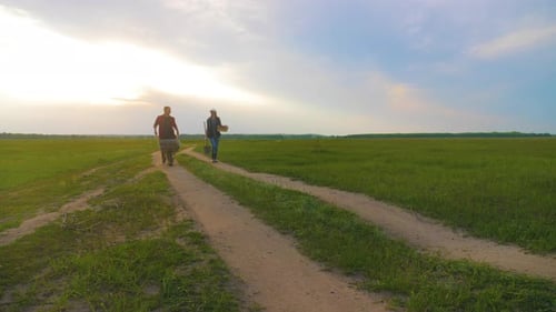 Farmers Walking Down Rural Path at Sunrise