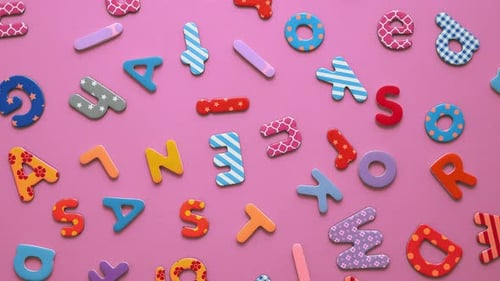 Colorful Plastic Alphabet Letters on Pink Background